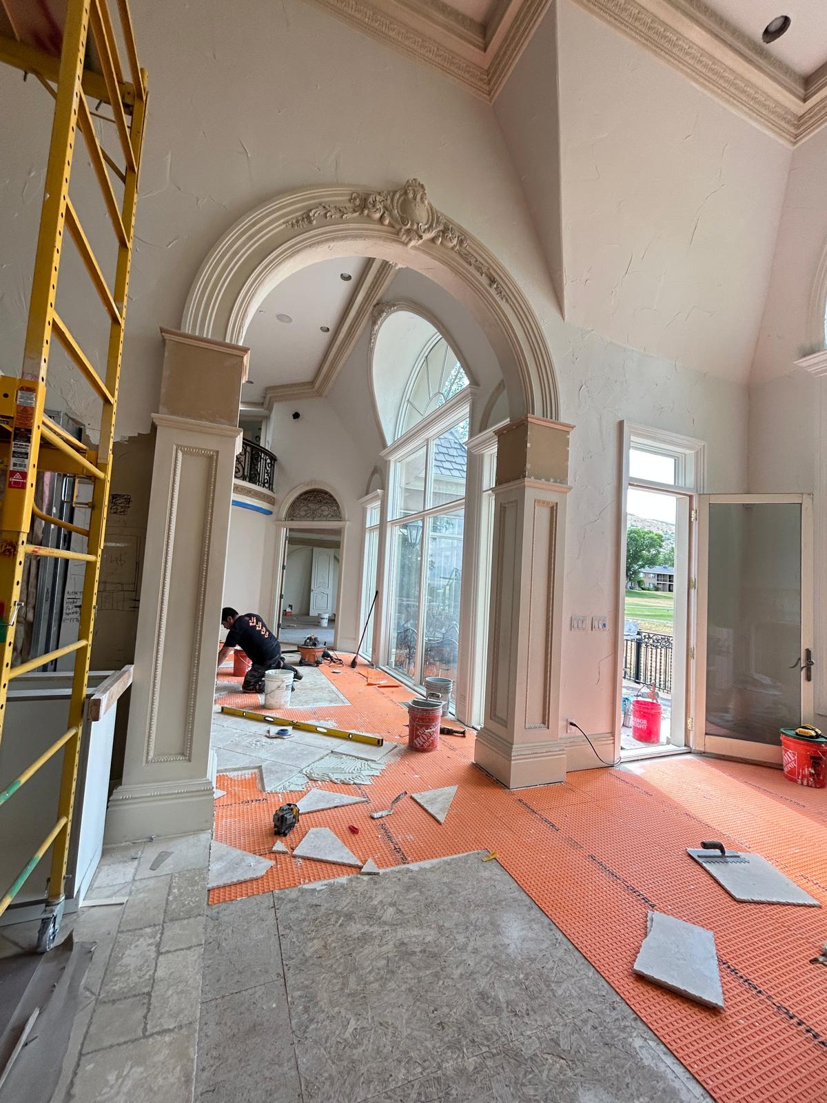 Ornate plaster archway and vaulted foyer with arched windows overlooking the entry during construction