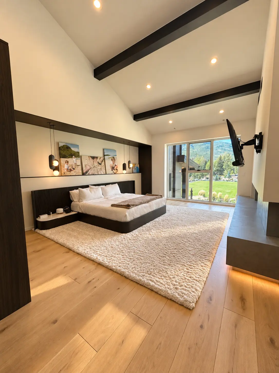 Primary bedroom with custom millwork, exposed beams, and mountain views
